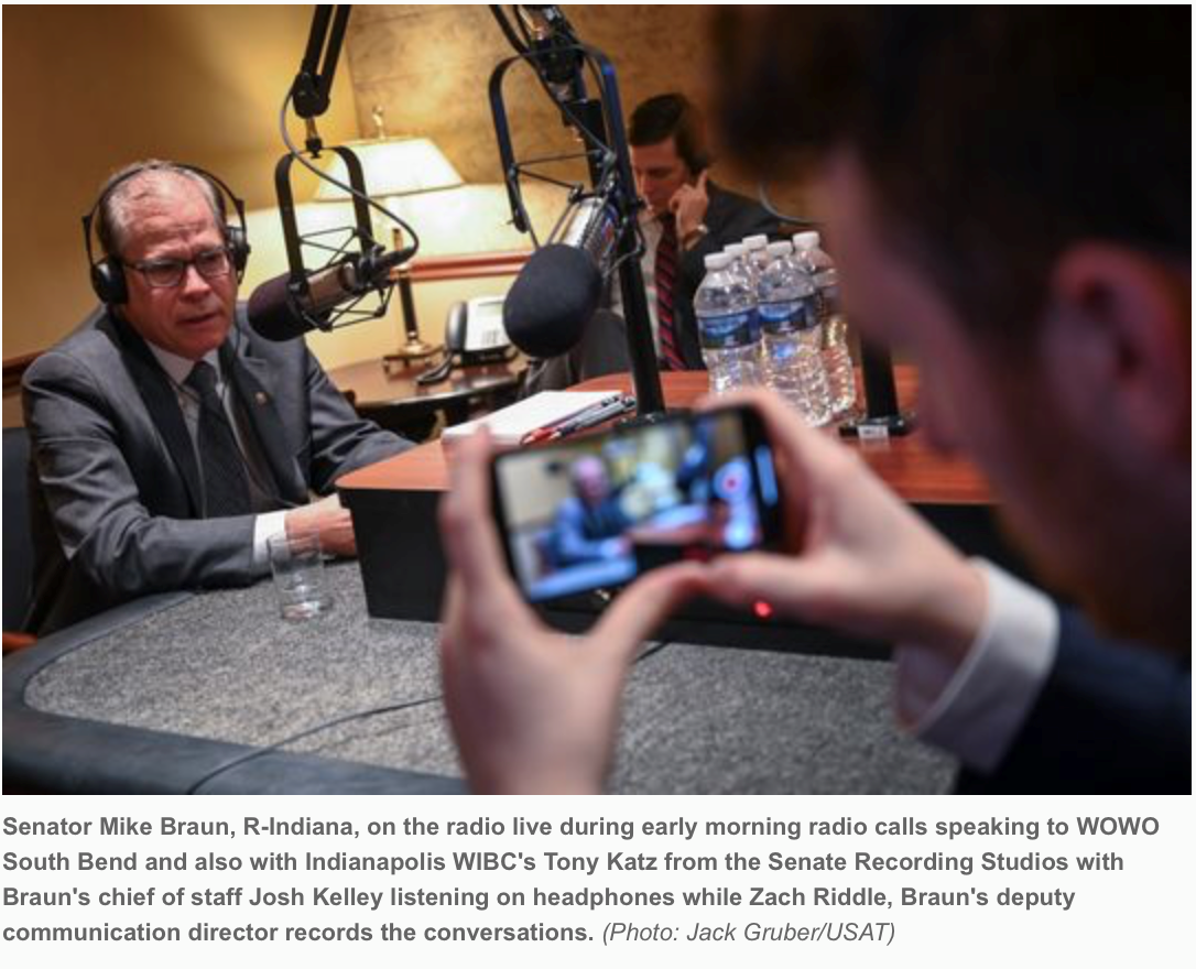 Senator Mike Braun, R-Indiana, on the radio live during early morning radio calls speaking to WOWO South Bend and also with Indianapolis WIBC's Tony Katz from the Senate Recording Studios with Braun's chief of staff Josh Kelley listening on headphones while Zach Riddle, Braun's deputy communication director records the conversation. (Photo credit: Jack Gruber/USAT)